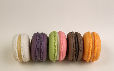 Colorful French macaroons on beige background