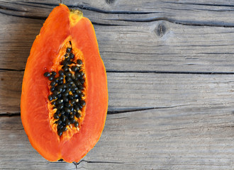 Fresh ripe organic papaya tropical fruit cut in half on old wooden background. Healthy eating,diet or vegan food concept.Selective focus.