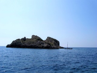 Fototapeta na wymiar boat near small rocky island