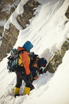 Climbers on a snowy mountain slope.