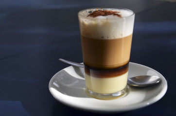 Traditional Canarian coffee Barraquito with separated layers of milk condensed and liquor on a dark background.Selective focus.