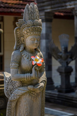 Statue holding frangipani flower at Pawon temple near Borobudur, Java, Indonesia.