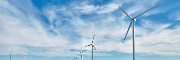 Wind power generator on blue sky background. Renewable energy source. Powerful and ecological...