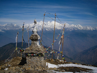 Stone temple high in the Himalaya mountains in the Langtang region of Nepal has colourful prayer flags fluttering around it in the breeze - obrazy, fototapety, plakaty