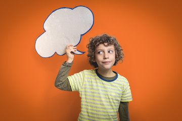 Real cardboard Speech bubble holded by a 6 years old kid isolated on a orange background