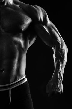 Muscular man's torso on black background with backlight Black and White photo