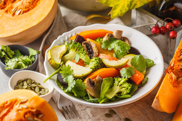 Autumn salad from baked pumpkin, beet, zucchini and carrots. Healthy vegan food concept.
