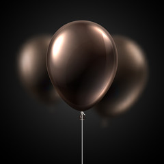 Brown glossy balloons isolated on black background. Festive decoration.