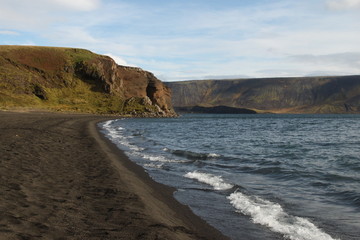 Fototapeta na wymiar Black sand beach with mountains