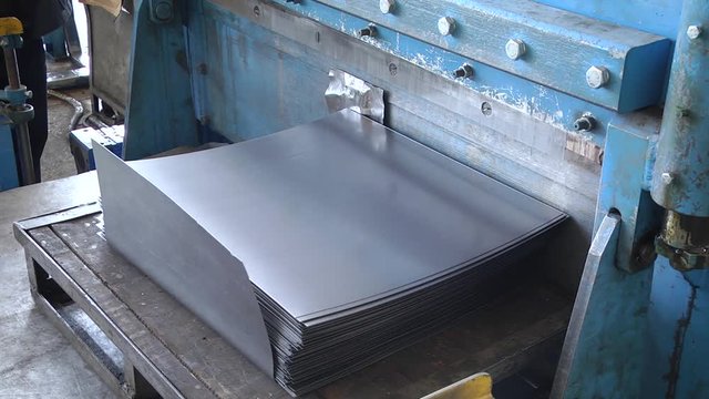 Sheet metal clipping. Guillotine for metal. The shop operates a press machine that cuts the sheets of metal.
