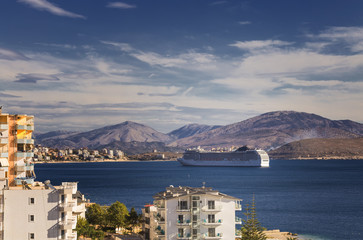 Big cruise ship sails to the sea port of Saranda, Albania. Albanian mountains in the background....
