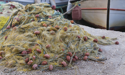 Traditional fishing net with floats on the shore after fishing on the background of boats.