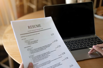 Businesswoman or job seeker review his resume in coffee shop before send to finding a new job with...