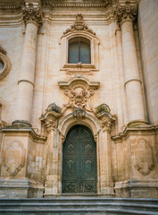 Fototapeta premium Ornate door to the Duomo of San Giorgio in Modica, fine example of sicilian baroque art. Sicily, southern Italy.