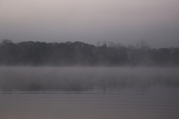 Fototapeta na wymiar Foggy sunrise on an autumn lake