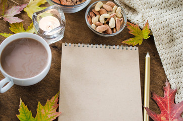 Blank brown notebook with knitted blanket, a cup of hot cocoa and snacks. Thanksgiving day concept.