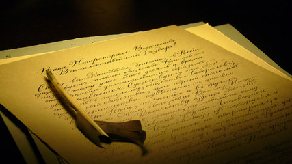 Quill pen and letter filled with handwriting text