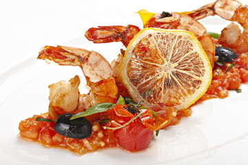 Close up of shrimps served with tomato sauces and slice of lemon.