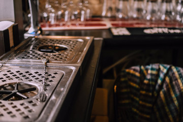 Clean glasses and bricked wall on the background. Hipsterish pub interior. Bartender's work space
