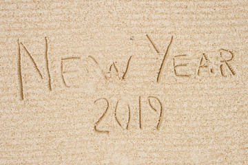 New Year 2019 logo. Conceptual photo of new year celebration. Tropical shore near ocean with holidays name written on sand.  Travel and rest on winter vacation. Resort beach.