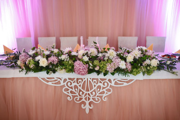 Wedding venue food table with flowers and delicious meal, in pink violet tones. concept design of the hall