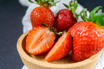 Strawberry on dark background with selective focus and crop fragment