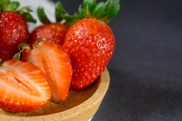 Strawberry on dark background with selective focus and crop fragment