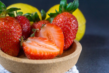 Strawberry on dark background with selective focus and crop fragment