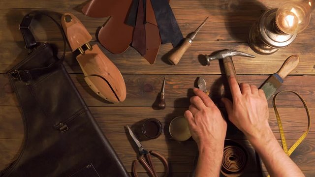 men's hands take tools for making shoes lie with a wooden table. The set of objects that symbolize manual labour, small business