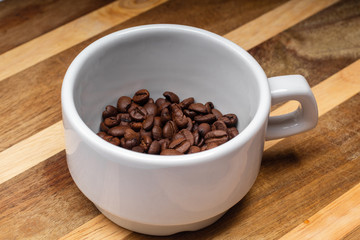 white cup of grain coffee on a saucer on the wooden background surface
