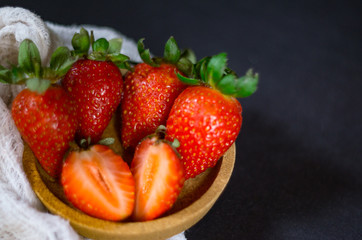 Strawberry on dark background with selective focus and crop fragment