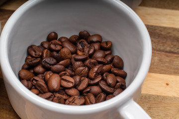 white cup of grain coffee on a saucer on the wooden background surface