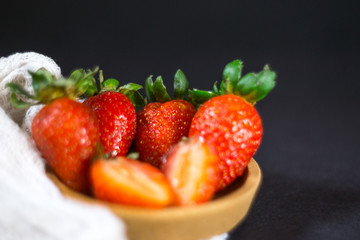 Strawberry on dark background with selective focus and crop fragment