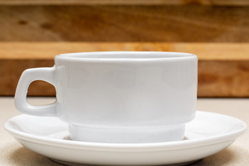 white cup of grain coffee on a saucer on the wooden background surface