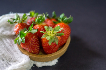 Strawberry on dark background with selective focus and crop fragment