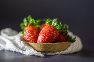 Strawberry on dark background with selective focus and crop fragment