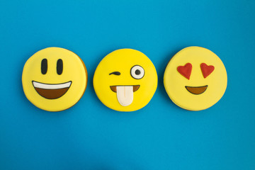 Smileys in the form of gingerbread on the blue background.Top view.Closeup.Copy space.