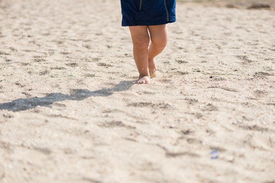 Baby feets on the sea sandy beach