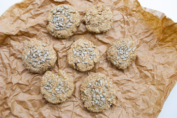 Homemade cereal oat cookies with seeds on rustic paper. Healthy desert.