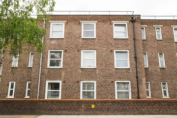 Exterior of red brick building facade with white windows