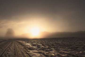 Fototapeta premium Winter road covered with snow at sunrise