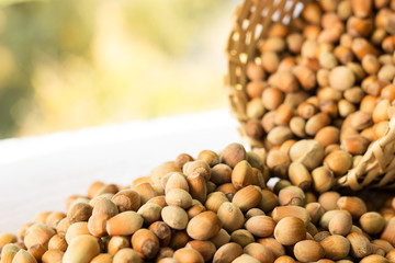 Hazelnuts in a wicker basket on old wooden table 