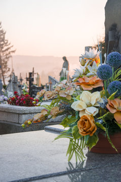 Floral decoration on the grave with a cementary in the background