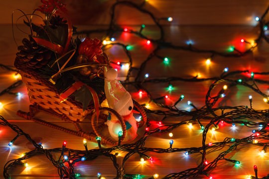 Christmas garland with a snowman in a sleigh with gifts. On wooden background