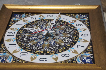 brown square hand-painted watch with contour acrylic paints in the technique point to point, with a geometric pattern in the form of a mandala, black numerals and white arrows