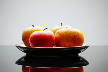 Äpfel von der Seite auf Teller auf Glastisch