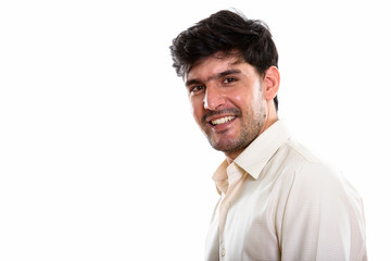 Studio shot of young happy Persian businessman smiling
