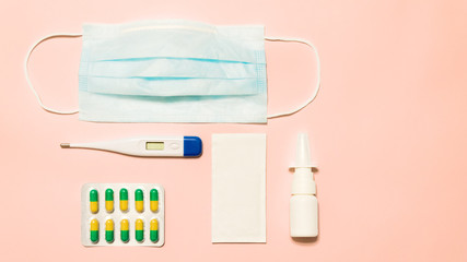 thermometer, mask and medication in pastel colors