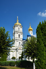 Fototapeta na wymiar Religious buildings, Orthodox Christian cathedral with golden domes. Huge religious complex. Bell tower in Holy Dormition Pochayiv Lavra, Ukraine.