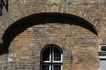 Arc shaped window on a brick wall, with arc brick shape above